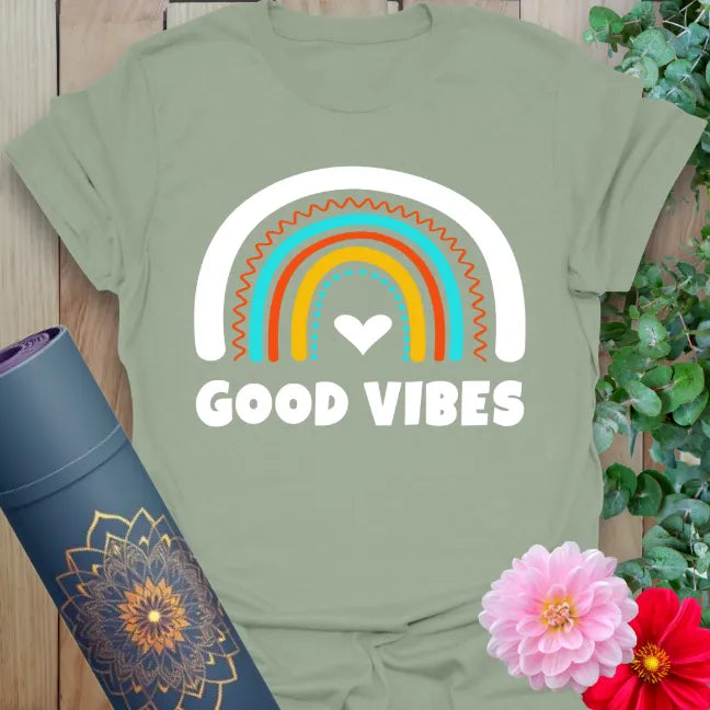 Sage green yoga t-shirt with colorful arched rainbow and bold type for conscious, happy everyday expression.