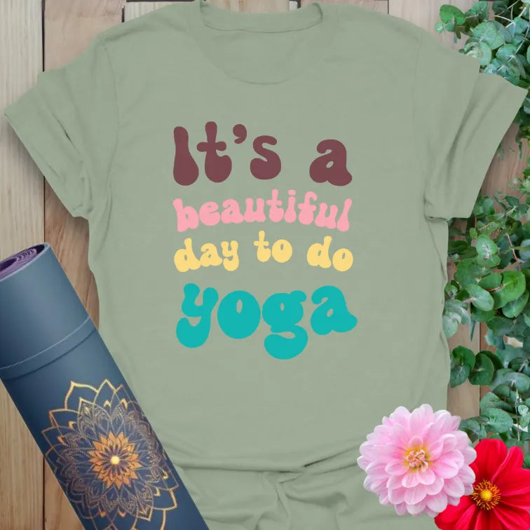 Sage green yoga t-shirt featuring cheerful quote design in colorful font for relaxed, mindful everyday wear.