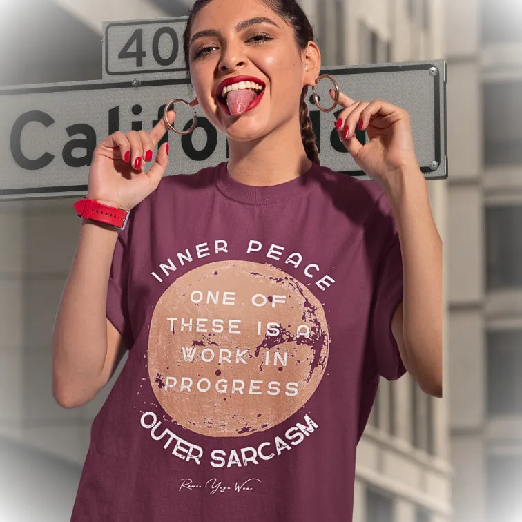 Person wearing the Sarcasm T-Shirt in Heather Cardinal, standing outdoors near a street sign, laughing — Funny Yoga Shirts collection by Ramro Yoga Wear.