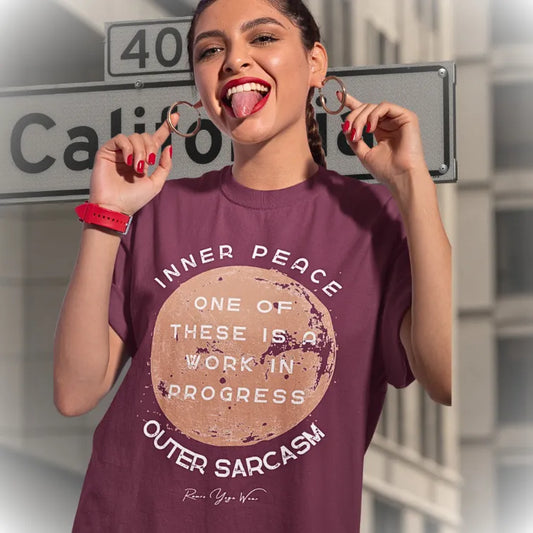 Person wearing the Sarcasm T-Shirt in Heather Cardinal, standing outdoors near a street sign, laughing — Funny Yoga Shirts collection by Ramro Yoga Wear.