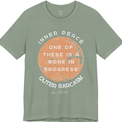 A grunge tee with a sun-washed circular design, text reading "Inner Peace," "One of these is a work in progress," and "Outer Sarcasm" — Funny Yoga Shirts collection by Ramro Yoga Wear in Sage.