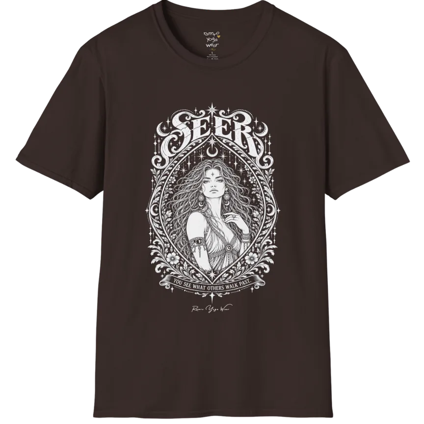 A short sleeved tee called the Seer T-Shirt, flat lay and a soft cotton shirt. Simply says, You see what others walk past. Design highlights an ornate engraved almond-shaped frame of florals and filigree around a close portrait of a long-haired figure with a star on the brow, crescent moon earrings and one hand at the collarbone, beneath a crescent moon and hanging stars, with Seer in decorative lettering across the top and the tagline on a banner below. Color is Dark Chocolate.