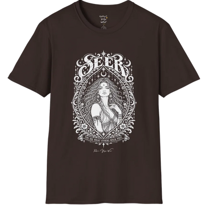 A short sleeved tee called the Seer T-Shirt, flat lay and a soft cotton shirt. Simply says, You see what others walk past. Design highlights an ornate engraved almond-shaped frame of florals and filigree around a close portrait of a long-haired figure with a star on the brow, crescent moon earrings and one hand at the collarbone, beneath a crescent moon and hanging stars, with Seer in decorative lettering across the top and the tagline on a banner below. Color is Dark Chocolate.