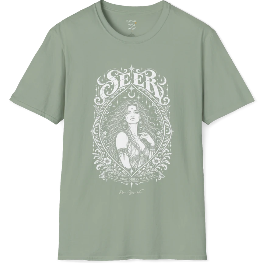 A short sleeved tee called the Seer T-Shirt, flat lay and a soft cotton shirt. Simply says, You see what others walk past. Design highlights an ornate engraved almond-shaped frame of florals and filigree around a close portrait of a long-haired figure with a star on the brow, crescent moon earrings and one hand at the collarbone, beneath a crescent moon and hanging stars, with Seer in decorative lettering across the top and the tagline on a banner below. Color is Sage.