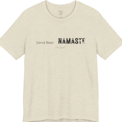 "Send Beer" in small script, followed by a  bold "NAMASTE" lettering. Send Beer T-Shirt flat lay is a Bella+Canvas 3001 and the color is Heather Prism Natural.