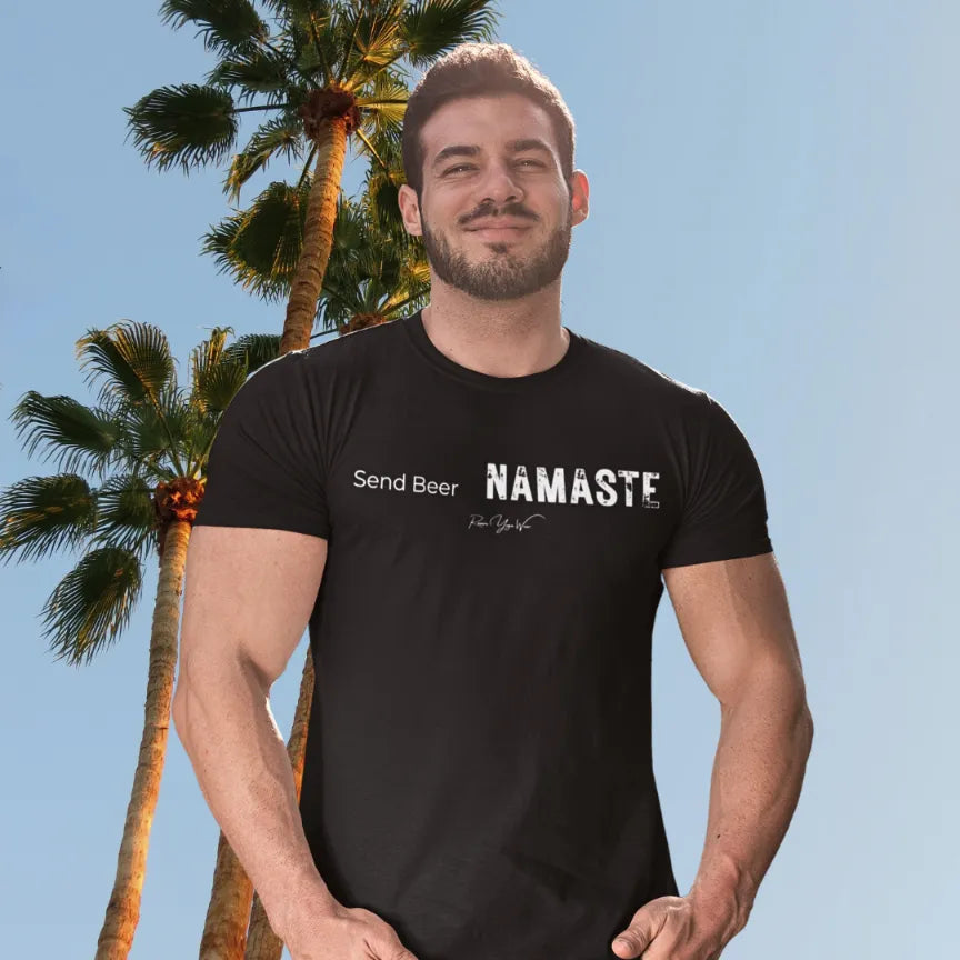 A man stands under palm trees against a blue sky, wearing the Send Beer T-Shirt. Send Beer T-Shirt is a Bella+Canvas 3001 and the color is Black.