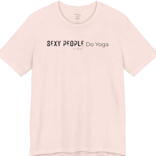 A short sleeved tee called the Sexy T-Shirt, flat lay and a soft cotton shirt. Simply says, Sexy People Do Yoga. Design highlights bold distressed block lettering for Sexy People beside lighter thin lettering for Do Yoga, with a small script signature underneath. Color is Soft Pink.
