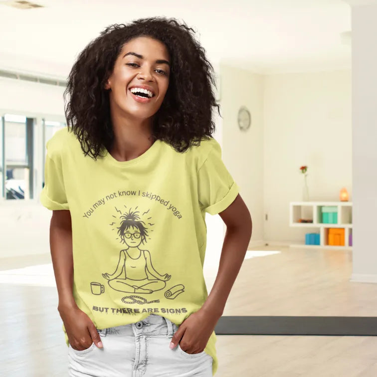 Woman wearing Signs T-Shirt Cornsilk sacred yoga shirt standing indoors in a bright colorful room — The Vault collection by Ramro Yoga Wear