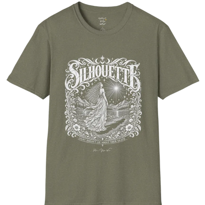 A short sleeved tee called the Silhouette T-Shirt, flat lay and a Gildan 64000 shirt on a white background. Simply says, Light Doesn't Lie About Your Shape. Design highlights a long-haired figure in a flowing gown gazing at a radiating star, framed by ornate florals, mountains and a lake, with the figure's cast shadow on the path. Color is Heather Military Green.