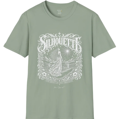 A short sleeved tee called the Silhouette T-Shirt, flat lay and a Gildan 64000 shirt on a white background. Simply says, Light Doesn't Lie About Your Shape. Design highlights a long-haired figure in a flowing gown gazing at a radiating star, framed by ornate florals, mountains and a lake, with the figure's cast shadow on the path. Color is Sage.