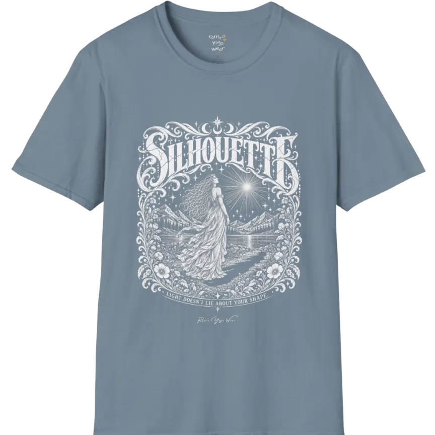 A short sleeved tee called the Silhouette T-Shirt, flat lay and a Gildan 64000 shirt on a white background. Simply says, Light Doesn't Lie About Your Shape. Design highlights a long-haired figure in a flowing gown gazing at a radiating star, framed by ornate florals, mountains and a lake, with the figure's cast shadow on the path. Color is Stone Blue.