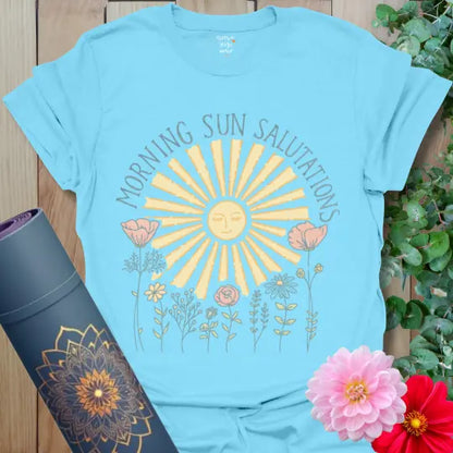 Sky Morning Sun Salutations T-Shirt with glowing sun and wildflowers in calming pastel tones. Yoga shirt celebrating balance and peace.