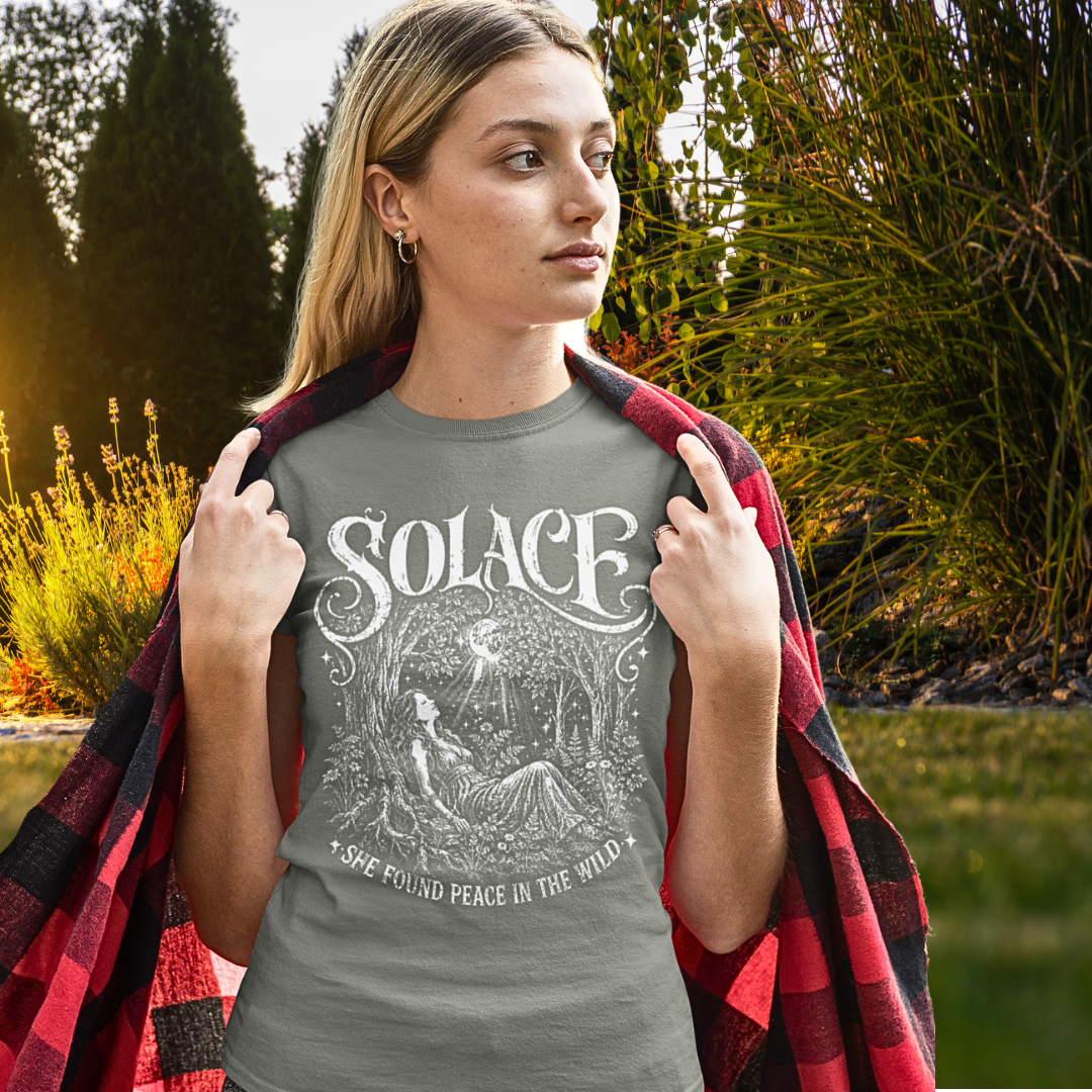 Person wearing Solace in Heather Military Green sacred yoga shirt in an autumn garden, wrapped in a plaid throw — Wild Devotion collection by Ramro Yoga Wear
