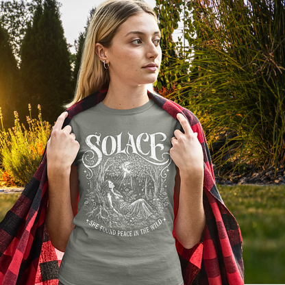 Person wearing Solace in Heather Military Green sacred yoga shirt in an autumn garden, wrapped in a plaid throw — Wild Devotion collection by Ramro Yoga Wear