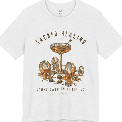 A grunge tee with an illustrated design of three cocktail glasses — one upright, two spilled with ice cubes and olives scattered — text reading "Sacred Healing" and "Sound Bath In Progress" — Funny Yoga Shirts collection by Ramro Yoga Wear in Ash.