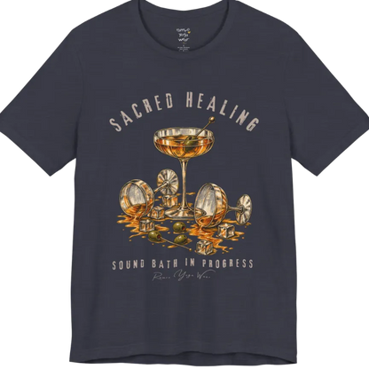 A grunge tee with an illustrated design of three cocktail glasses — one upright, two spilled with ice cubes and olives scattered — text reading "Sacred Healing" and "Sound Bath In Progress" — Funny Yoga Shirts collection by Ramro Yoga Wear in Heather Midnight Navy.