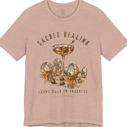 A grunge tee with an illustrated design of three cocktail glasses — one upright, two spilled with ice cubes and olives scattered — text reading "Sacred Healing" and "Sound Bath In Progress" — Funny Yoga Shirts collection by Ramro Yoga Wear in Heather Prism Peach.