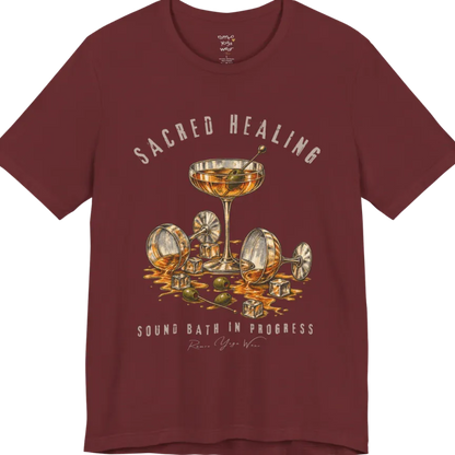 A grunge tee with an illustrated design of three cocktail glasses — one upright, two spilled with ice cubes and olives scattered — text reading "Sacred Healing" and "Sound Bath In Progress" — Funny Yoga Shirts collection by Ramro Yoga Wear in Heather Cardinal.