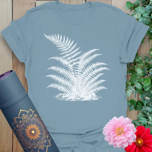Muted stone blue yoga t-shirt with white fern design embodying earth connection and soulful movement.