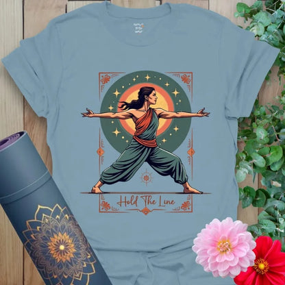 Muted stone blue yoga t-shirt featuring cosmic Warrior II yogi design symbolizing grounded resilience and mindful courage.