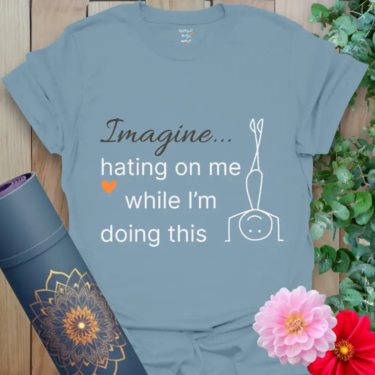 Stone Blue Imagine T-Shirt with humorous yoga quote “Imagine hating on me while I’m doing this.” Minimalist headstand art and orange heart — confident, calm, and cheeky.