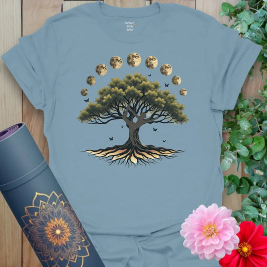Muted stone blue yoga t-shirt with majestic tree and full lunar cycle design symbolizing balance, growth, and cosmic connection.