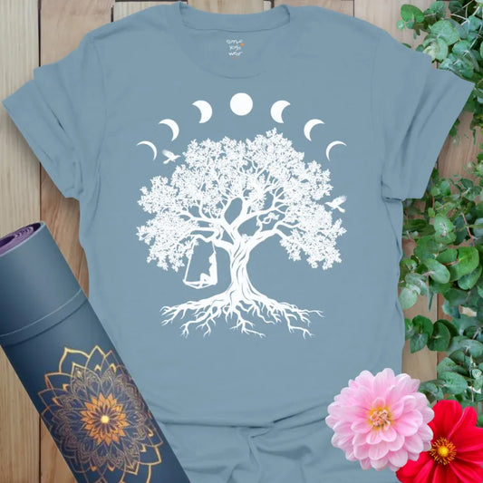 Muted stone blue yoga t-shirt with celestial tree and swinging figure artwork inspiring balance, freedom, and soulful movement.