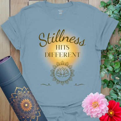 Stone Blue Stillness Hits T-Shirt with soft gold text and a glowing mandala lotus. A calm, centered yoga tee for mindful everyday wear.