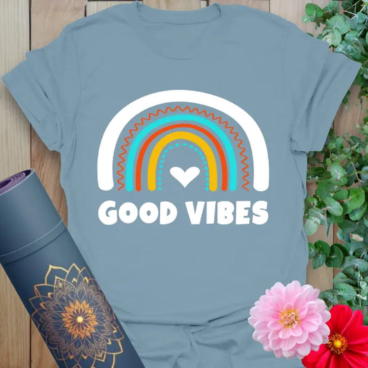 Muted stone blue yoga t-shirt featuring rainbow heart graphic and bright affirmation for light-hearted mindful wear.