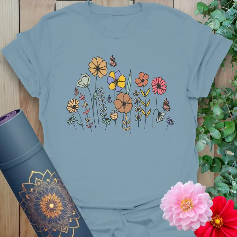 Muted stone blue t-shirt featuring hand-sketched wildflowers and nature motifs for soft, conscious comfort.