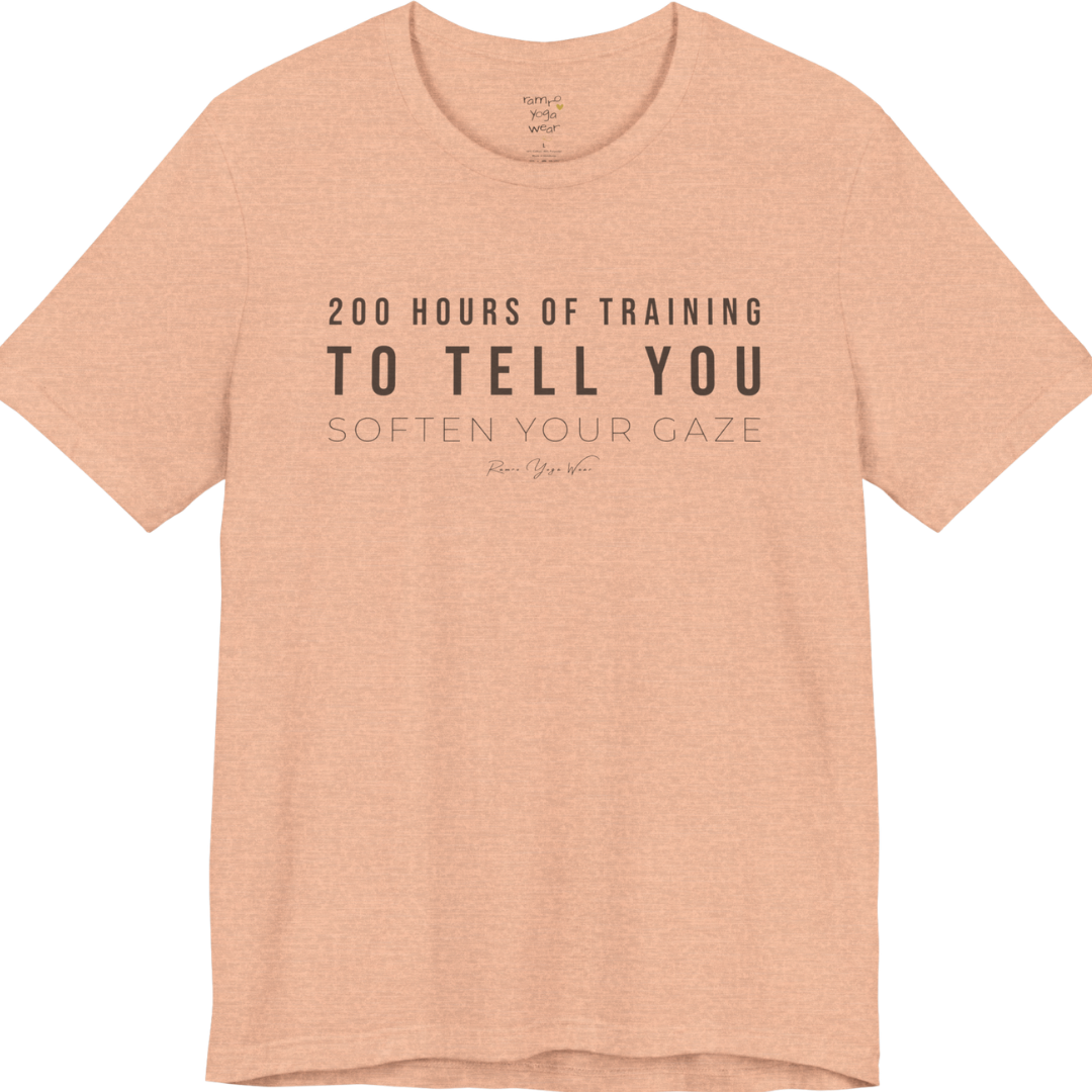200 HOURS OF TRAINING TO TELL YOU SOFTEN YOUR GAZE yoga teacher gift tee flat lay in Heather Peach — Yoga Teacher Gifts collection by Ramro Yoga Wear