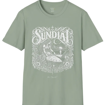 A short sleeved tee called the Sundial T-Shirt, flat lay and a Gildan 64000 shirt. Simply says, Read What You Cast. Design highlights a woman reading a sundial beneath a starry sky, with mountains and a rising sun in the background, in a detailed vintage-inspired illustration. Color is Sage.