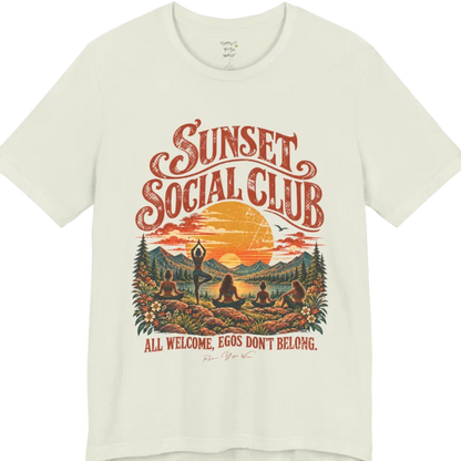 A short sleeved tee called the Sunset T-Shirt, flat lay and a Bella + Canvas 3001 shirt. Simply says, Sunset Social Club, All Welcome, Egos Don't Belong. Design highlights several people meditating together across a mountain landscape at sunset, with a large setting sun, pine trees, and florals, in a color vintage travel-poster illustration. Color is Citron.