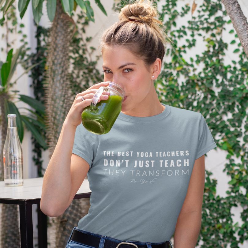 Woman wearing Transform Heather Blue Lagoon yoga teacher gift tee drinking a green juice outdoors — Yoga Teacher Gifts collection by Ramro Yoga Wear