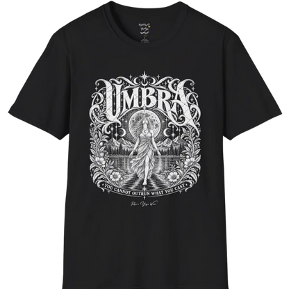 A short sleeved tee called the Umbra T-Shirt, flat lay and a Gildan 64000 shirt. Simply says, You Cannot Outrun What You Cast. Design highlights a moon goddess walking across still water toward distant mountains, framed in ornate vintage lettering with botanical detailing. Color is Black.
