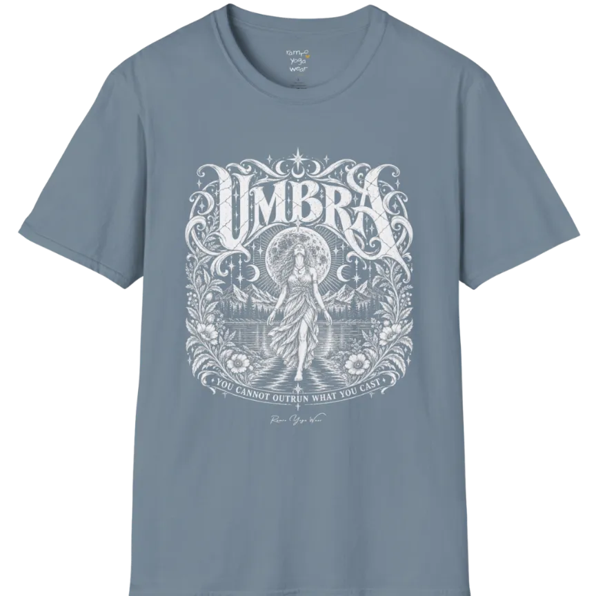 A short sleeved tee called the Umbra T-Shirt, flat lay and a Gildan 64000 shirt. Simply says, You Cannot Outrun What You Cast. Design highlights a moon goddess walking across still water toward distant mountains, framed in ornate vintage lettering with botanical detailing. Color is Stone Blue.
