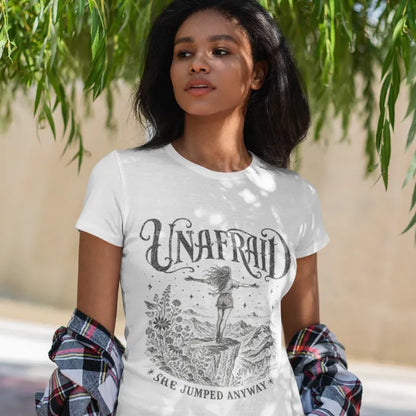 Woman wearing the White Unafraid T-Shirt in a natural outdoor setting featuring celestial Western-inspired artwork and soulful feminine energy.