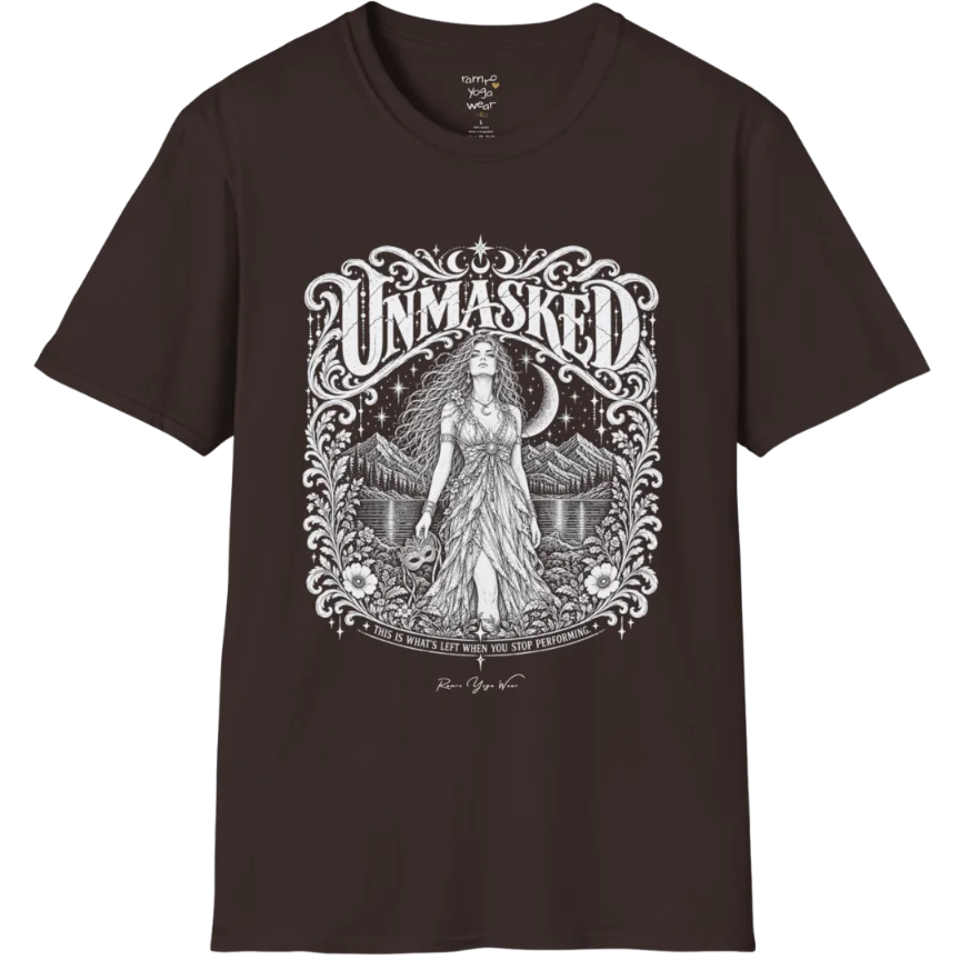 A short sleeved tee called the Unmasked T-Shirt, flat lay and a soft cotton shirt. Simply says, Unmasked. Design highlights an ornate floral crest in white linework with a long-haired figure in a flowing gown beneath a crescent moon, with Unmasked in ornate lettering across the top. Color is Dark Chocolate.