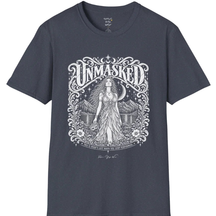 A short sleeved tee called the Unmasked T-Shirt, flat lay and a soft cotton shirt. Simply says, Unmasked. Design highlights an ornate floral crest in white linework with a long-haired figure in a flowing gown beneath a crescent moon, with Unmasked in ornate lettering across the top. Color is Heather Navy.