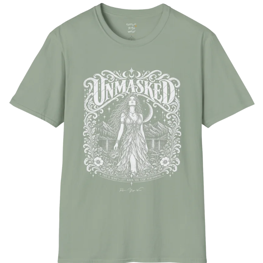 A short sleeved tee called the Unmasked T-Shirt, flat lay and a soft cotton shirt. Simply says, Unmasked. Design highlights an ornate floral crest in white linework with a long-haired figure in a flowing gown beneath a crescent moon, with Unmasked in ornate lettering across the top. Color is Sage.