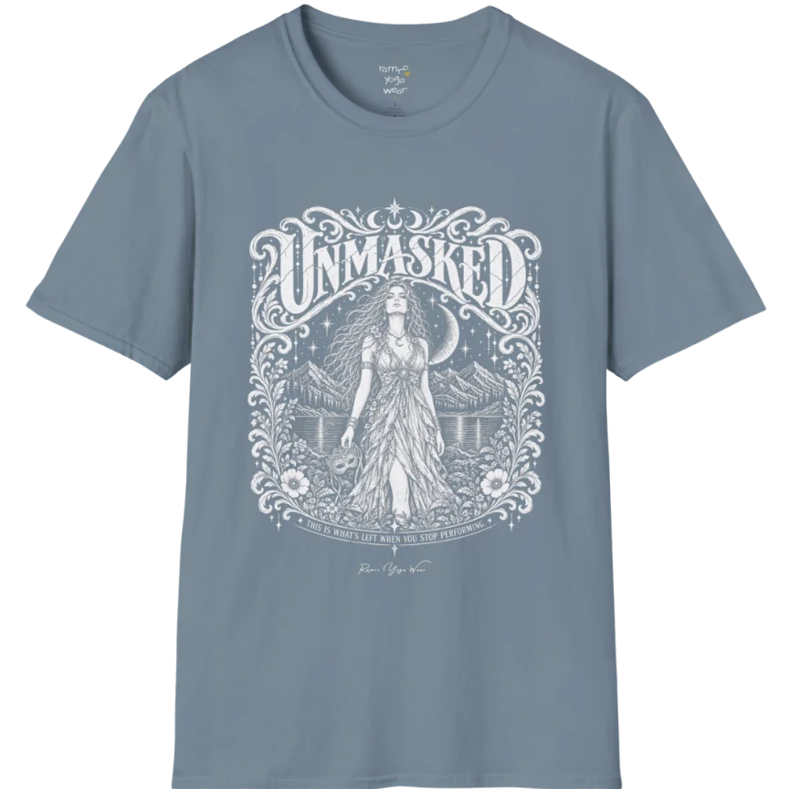 A short sleeved tee called the Unmasked T-Shirt, flat lay and a soft cotton shirt. Simply says, Unmasked. Design highlights an ornate floral crest in white linework with a long-haired figure in a flowing gown beneath a crescent moon, with Unmasked in ornate lettering across the top. Color is Stone Blue.