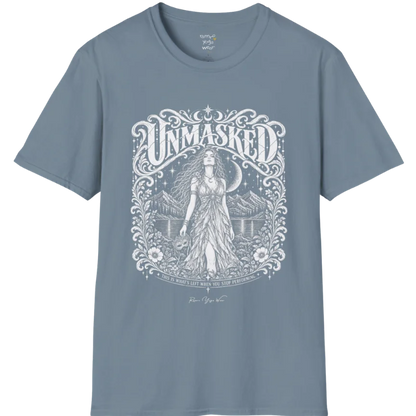 A short sleeved tee called the Unmasked T-Shirt, flat lay and a soft cotton shirt. Simply says, Unmasked. Design highlights an ornate floral crest in white linework with a long-haired figure in a flowing gown beneath a crescent moon, with Unmasked in ornate lettering across the top. Color is Stone Blue.