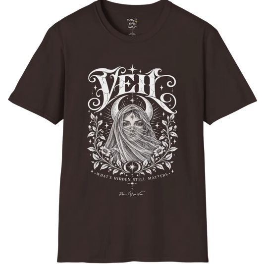 A short sleeved Tee, illustrated with a face partially obscured behind sheer draped fabric, a crescent moon behind, fine botanical framing at the base. Veil T-Shirt flat lay is a Gildan 64000 and the color is Dark Chocolate.