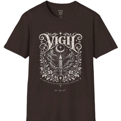 Short sleeved tee, illustration of a single candle burning steady against stormy clouds and wind lines, flame untouched, fine botanical framing at the base. Vigil T-Shirt flat lay is a Gildan 64000 and the color is Dark Chocolate.