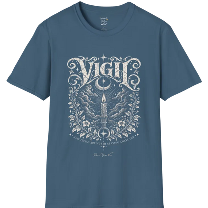 Short sleeved tee, illustration of a single candle burning steady against stormy clouds and wind lines, flame untouched, fine botanical framing at the base. Vigil T-Shirt flat lay is a Gildan 64000 and the color is Indigo Blue.