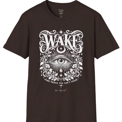 A short sleeved tee with an illustration of a single open eye amid darkness with a dewdrop caught mid-fall beneath it, faint stars scattered around, fine botanical framing at the base. Wake T-Shirt flat lay is a Gildan 64000 and the color is Dark Chocolate.