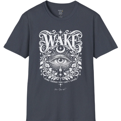 A short sleeved tee with an illustration of a single open eye amid darkness with a dewdrop caught mid-fall beneath it, faint stars scattered around, fine botanical framing at the base. Wake T-Shirt flat lay is a Gildan 64000 and the color is Heather Navy.