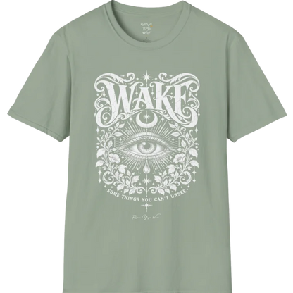 A short sleeved tee with an illustration of a single open eye amid darkness with a dewdrop caught mid-fall beneath it, faint stars scattered around, fine botanical framing at the base. Wake T-Shirt flat lay is a Gildan 64000 and the color is Sage.