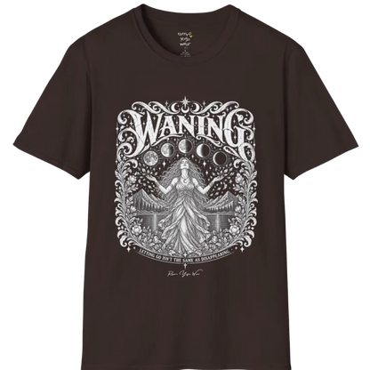 A short sleeved tee called the Waning T-Shirt, flat lay and a Gildan 64000 shirt. Simply says, Waning, Letting Go Isn't The Same As Disappearing. Design highlights a vintage-engraved crest of a robed figure with long flowing hair and open hands releasing petals beneath five moon phases, with mountains, a still lake, stars and ornate floral framing. Color is Dark Chocolate.