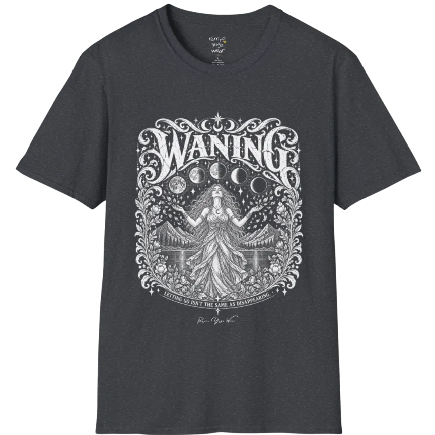 A short sleeved tee called the Waning T-Shirt, flat lay and a Gildan 64000 shirt. Simply says, Waning, Letting Go Isn't The Same As Disappearing. Design highlights a vintage-engraved crest of a robed figure with long flowing hair and open hands releasing petals beneath five moon phases, with mountains, a still lake, stars and ornate floral framing. Color is Dark Heather Grey.